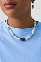 Collana con perline di pietra, perline bianche con fiori blu e conchiglia vistosa