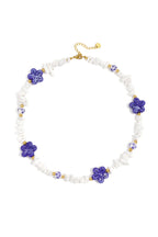 Collana con perline di pietra, perline bianche con fiori blu e fiori vistosi