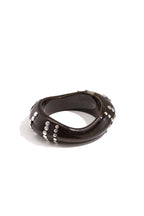 Bracciale rigido in resina con borchie a righe.