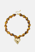 Collana di perline con perline dalla forma naturale e un cuore pendente.