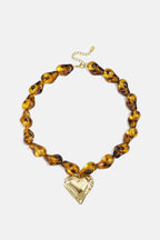 Collana di perline con perline dalla forma naturale e un cuore pendente.