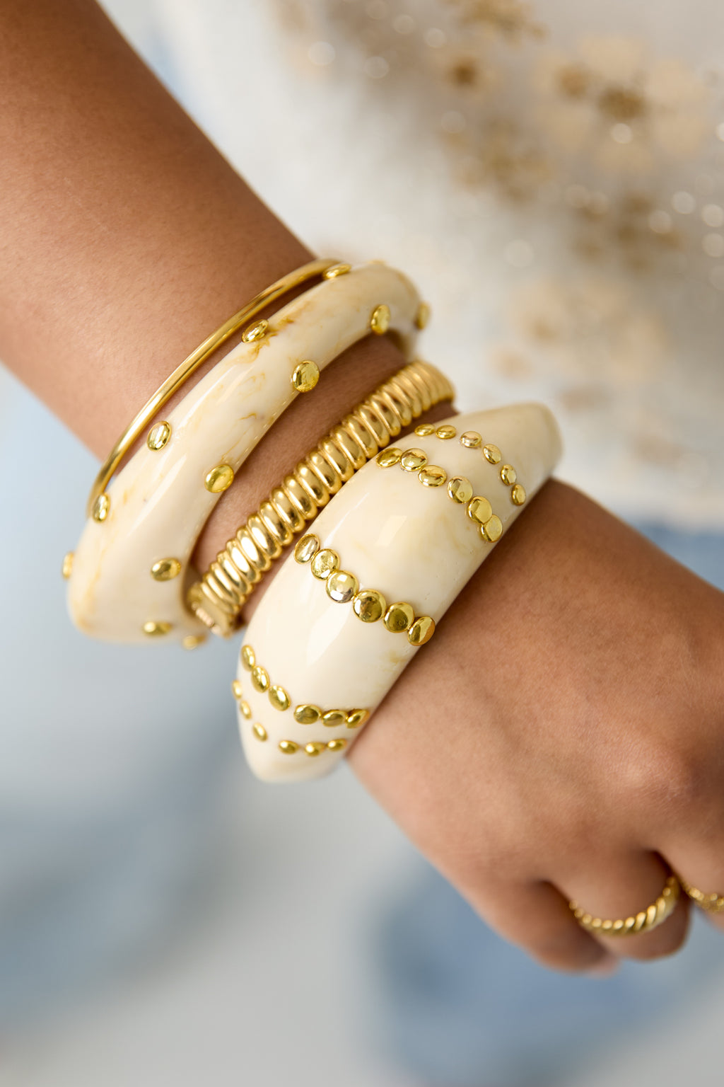 Bracciale rigido in resina con borchie a righe.
