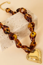 Collana di perline con perline dalla forma naturale e un cuore pendente.