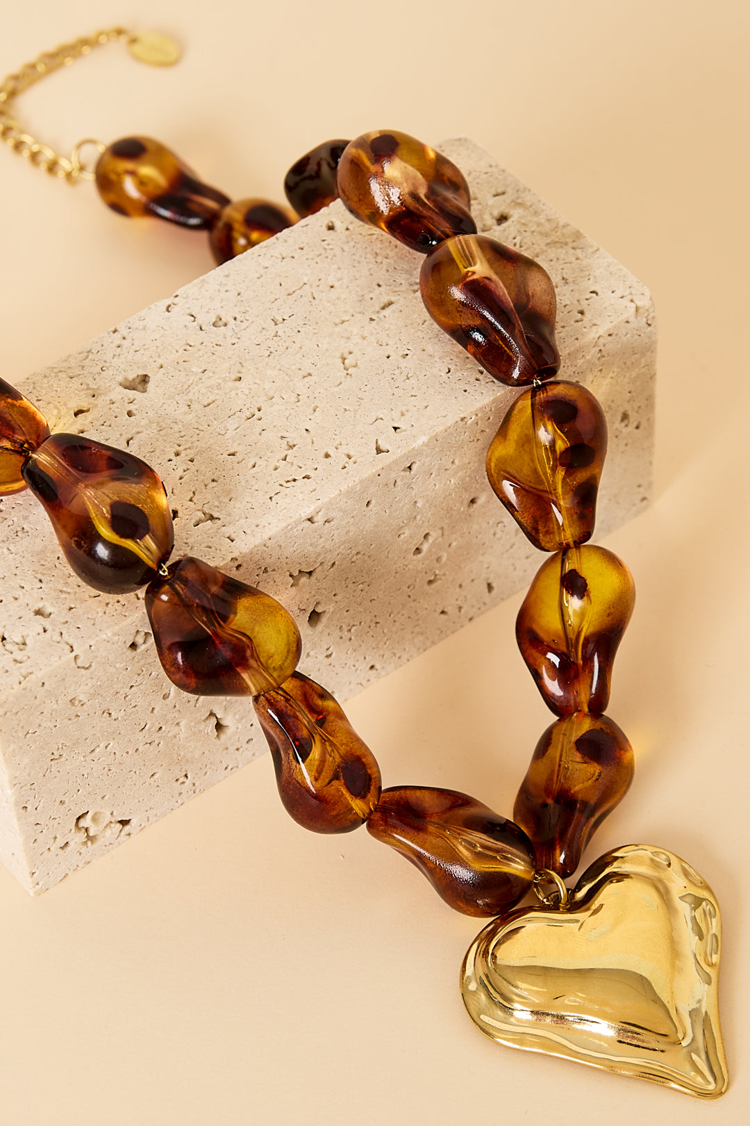 Collana di perline con perline dalla forma naturale e un cuore pendente.