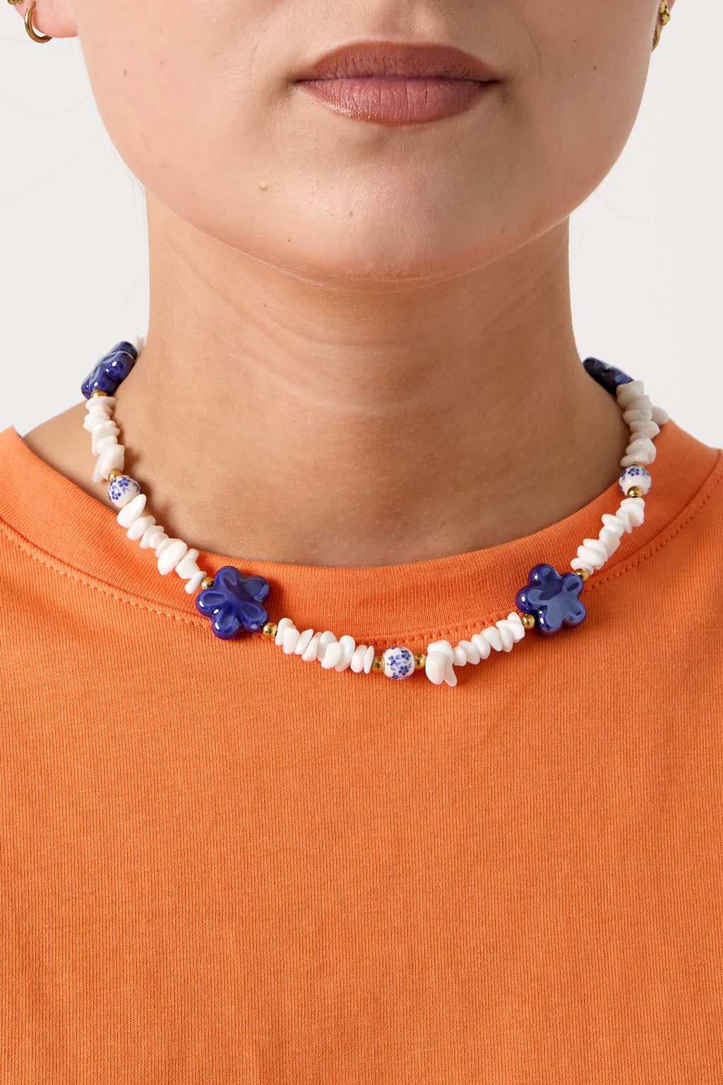 Collana con perline di pietra, perline bianche con fiori blu e fiori vistosi
